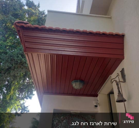 גג רעפים אדום עם תאורה תחתיו